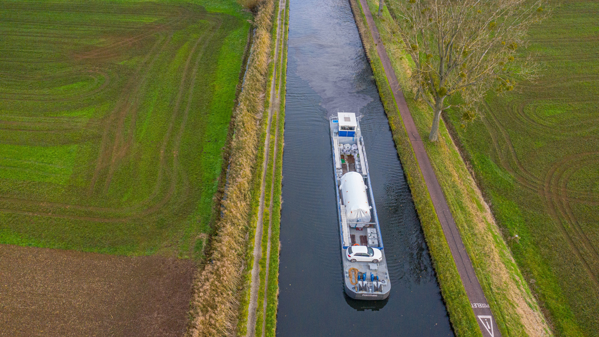 Schiff fährt über kleinen Fluss mit viel Grün